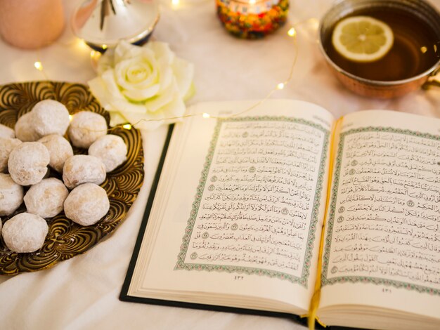 Top view quran with tea and pastry