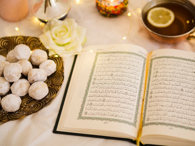 Top view quran with tea and pastry