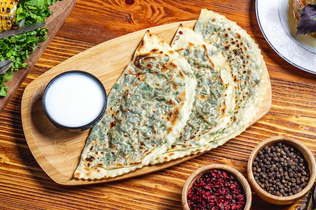 Foto gratuita vista dall'alto qutab con yogurt verde essiccato crespino e pepe nero in tavola