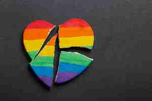 Free photo top view rainbow broken heart on dark background