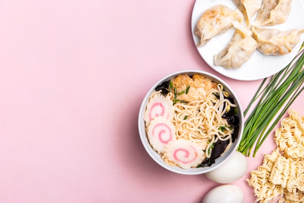 Top view ramen soup dumplings and ingredients with copy space