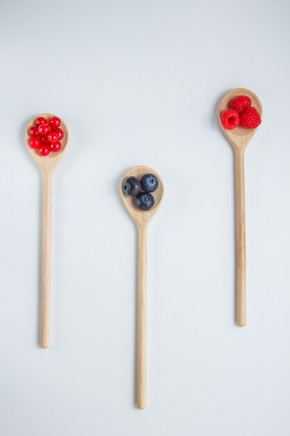 Top view raspberries in spoon with blueberries.