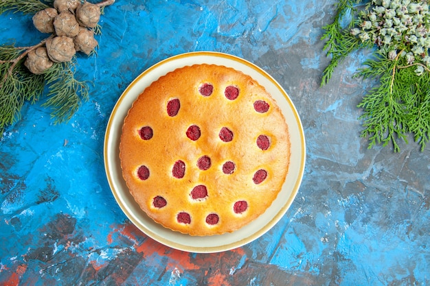 Top view of raspberry cake on plate cones on blue surface