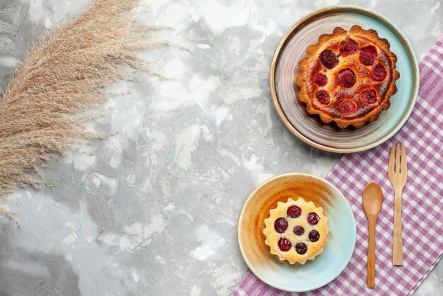 Top view raspberry cake with little cake on light desk fruit berry cake bake pie