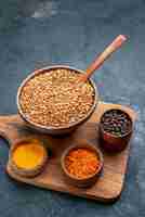 Free photo top view raw buckwheat with seasonings on a dark-grey space