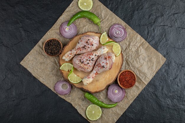 Top view raw chicken drumstick and vegetables.