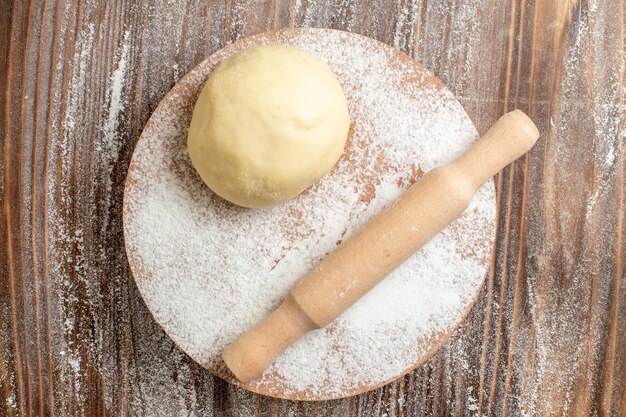 Top view raw dough piece with flour on a wooden desk meal flour bake dough