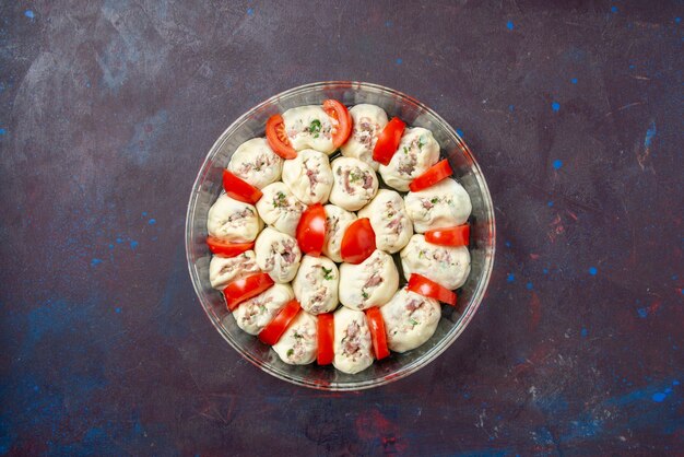 Top view raw dough pieces with ground meat and fresh red tomatoes inside pan on dark meal bake cuisine color photo