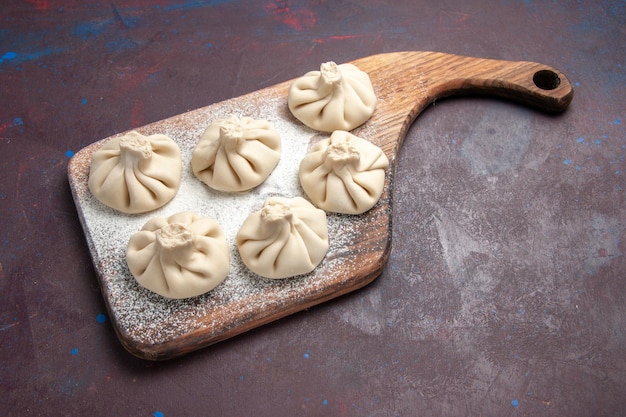 Top view of raw dumpling dough on black