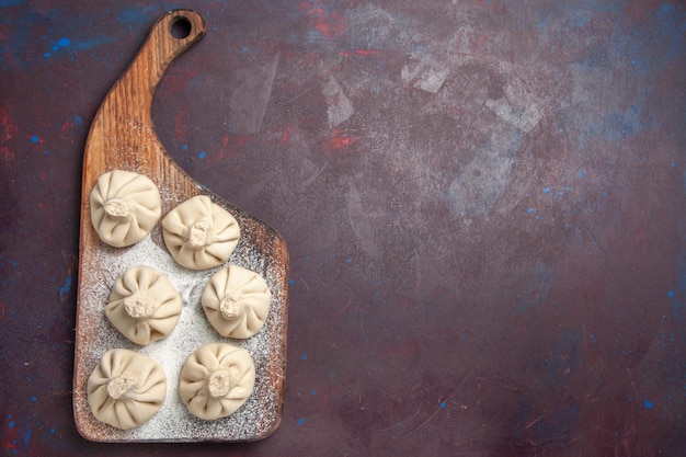 Top view of raw dumpling dough on black