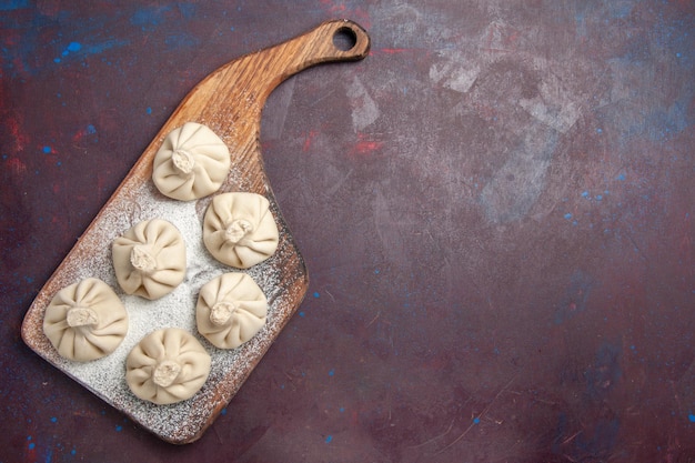 Top view of raw dumpling dough on black