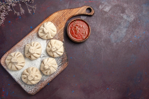 Top view of raw dumplings dough on black