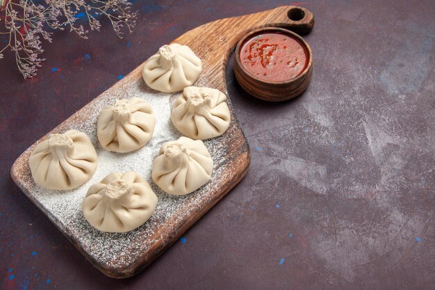 Top view of raw dumplings dough on black