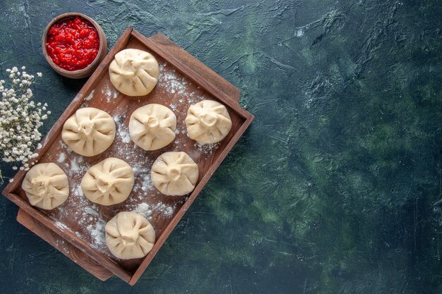 Top view raw dumplings with meat inside on a dark background color meal dough meat flour dish cooking pepper