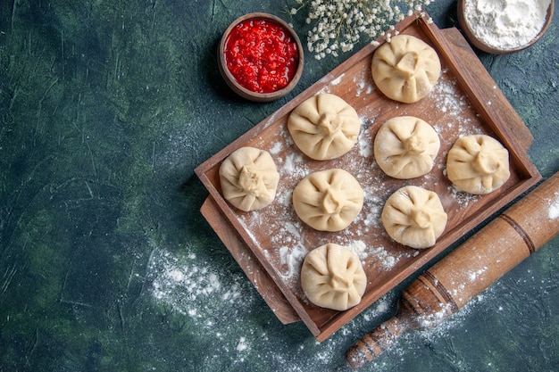 Бесплатное фото Вид сверху сырые пельмени с мясом внутри на темном фоне еда приготовление муки перец блюдо тесто мясо