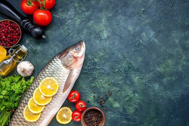 Top view raw fish pepper grinder tomatoes on table with free space