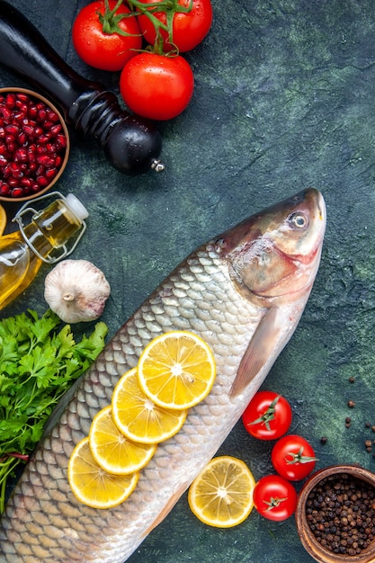 Free photo top view raw fish pepper grinder tomatoes on table