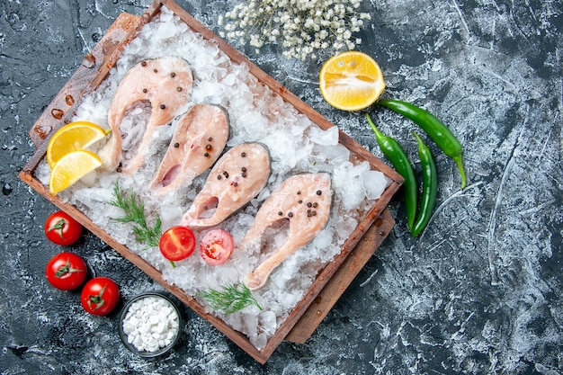 木の板の上の氷とテーブルの上の小さなボウル野菜の海塩の上面図生の魚のスライス