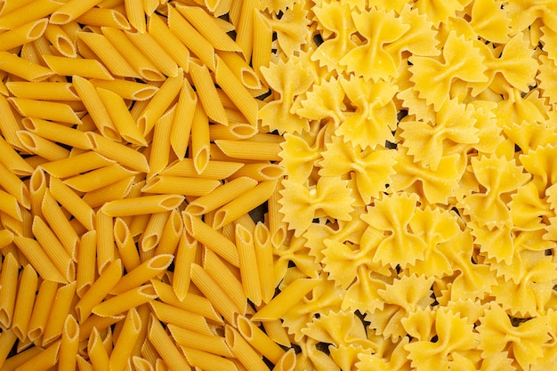 Top view raw italian pasta different formed on light-grey background