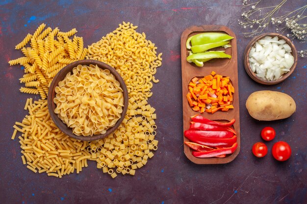 上面図生のイタリアンパスタ異なる形成された小さなパスタとスライスしたピーマンが暗い表面に食品生のイタリアンパスタミールカラー
