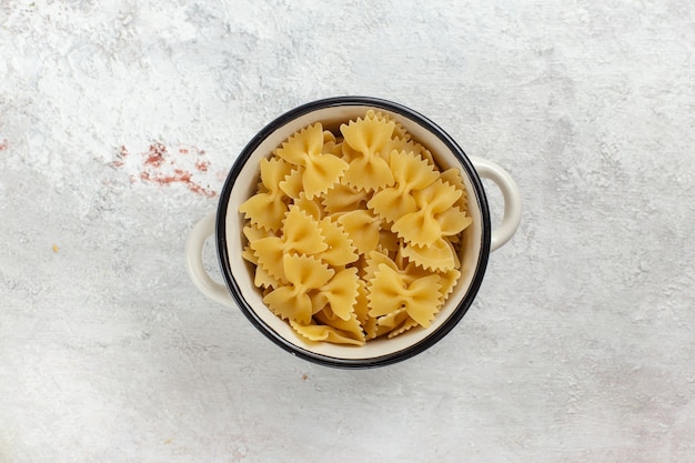 Top view raw italian pasta inside little pan on white background food meal raw photo