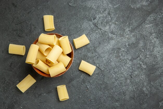 Top view raw italian pasta little formed on grey background food pasta raw meal dough