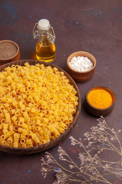 Top view raw italian pasta little formed inside plate on the dark background pasta food dough dinner raw many