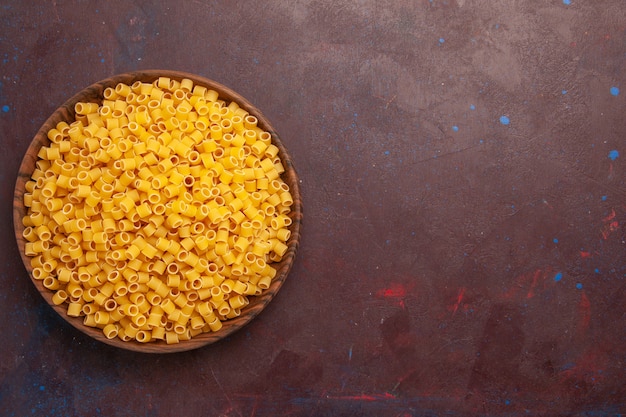 Top view raw italian pasta little formed inside plate on dark background pasta meal food dough many