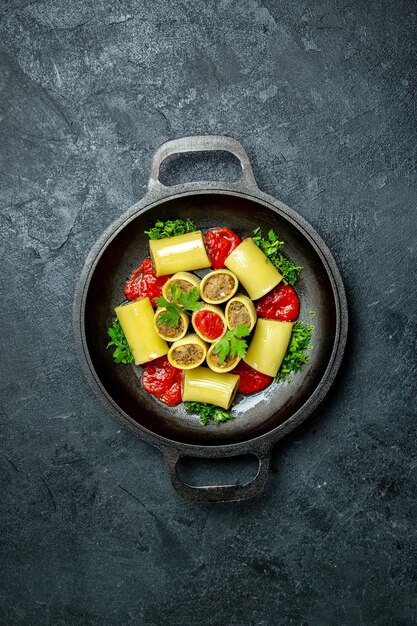 Top view raw italian pasta with meat greens and tomato sauce inside pan on dark background pasta dough meal food