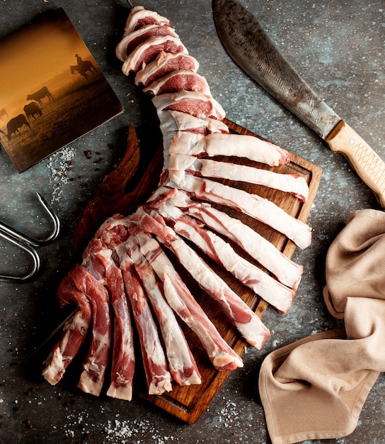 Top view of raw lamb ribs cuts placed on wooden cutting board