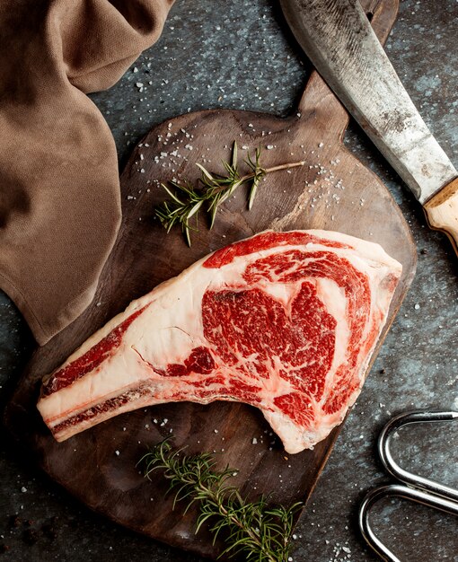 Top view of raw lamb thigh piece garnished with salt