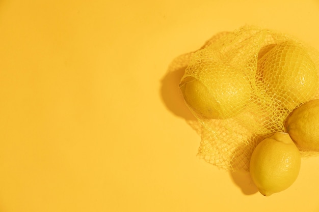 Free photo top view raw lemons in a bag