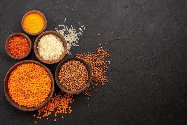 Top view raw lentil with buckwheat on dark desk