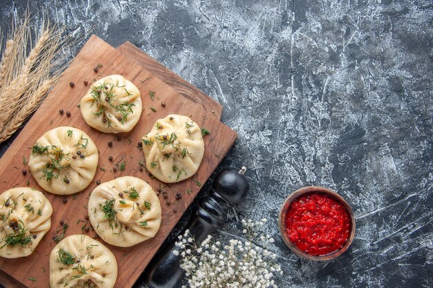 Top view raw little dumplings on gray background dough meal cake dinner meat cooking dish