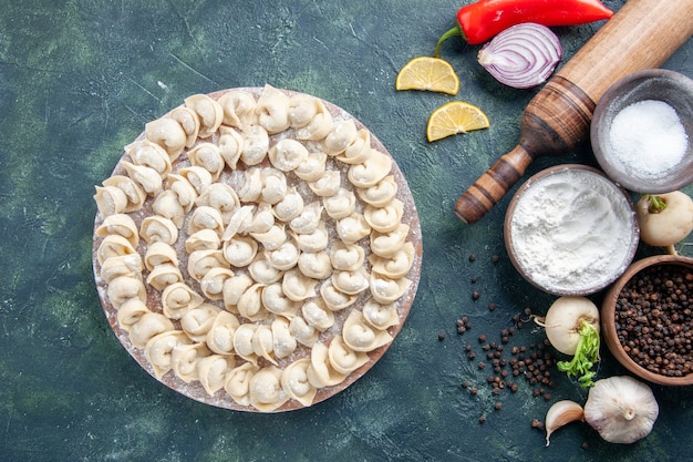 Vista dall'alto gnocchi crudi con farina e verdure su sfondo scuro pasta di carne piatto alimentare calorie colore pasto vegetale