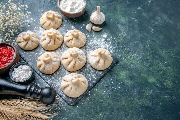 Top view raw little dumplings with meat inside on a dark background meat pepper color dish dough flour cooking meal cuisine