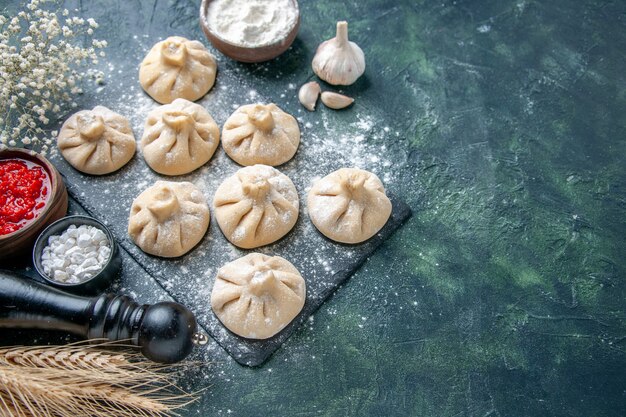 Top view raw little dumplings with meat inside on a dark background meat pepper color dish dough flour cooking meal cuisine