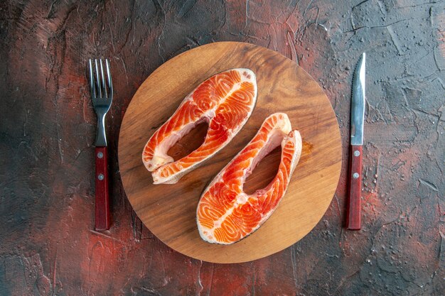 Top view raw meat slices on dark background