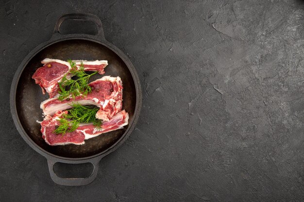 Top view raw meat slices with greens inside pan on dark background raw cow photo pepper chicken meat color animal free space