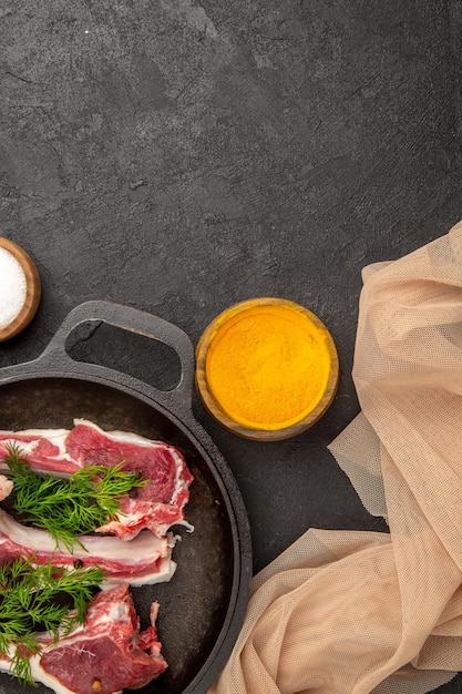 Foto gratuita vista dall'alto fette di carne cruda con verdure e condimenti sullo sfondo scuro foto di mucca cruda pepe carne colore pollo animale