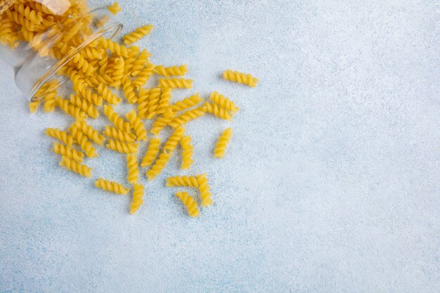 Top view of raw pasta in a jar on a gray surface