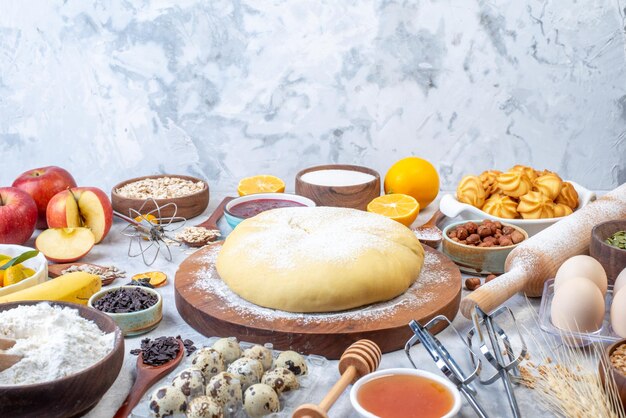 Top view of raw pastry and set of various foods grater on ice background