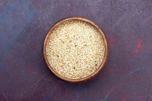 Top view of raw product inside round brown pot on dark surface