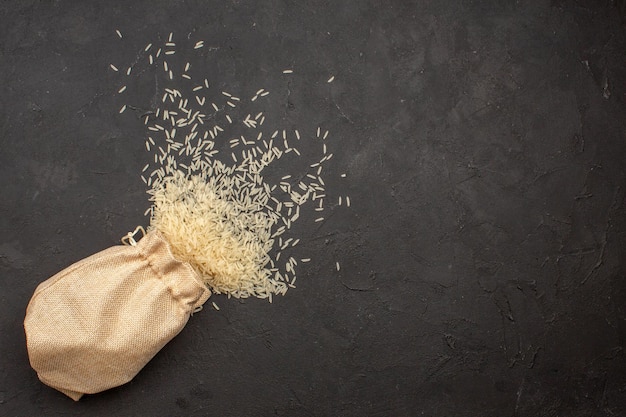 Free photo top view of raw rice inside bag on grey surface