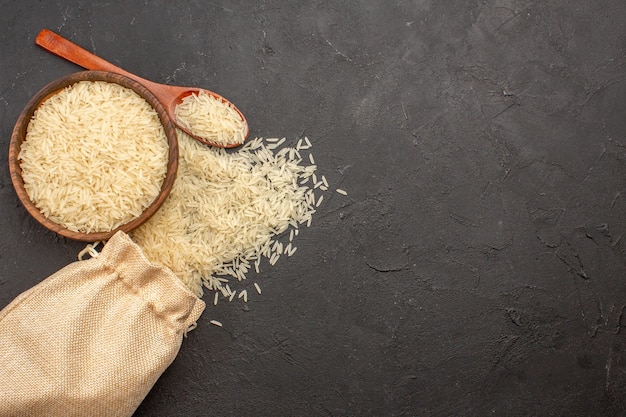 Free photo top view of raw rice inside brown plate on grey surface