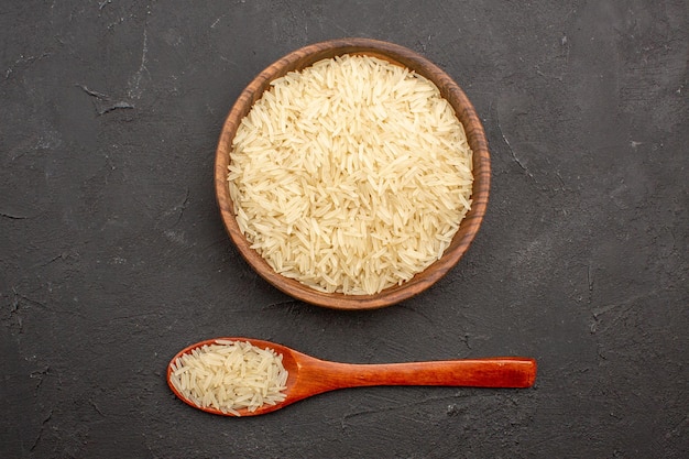 Free photo top view of raw rice inside brown plate on the grey surface