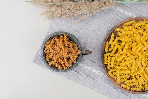 Top view of raw spiral pasta on on tablecloth