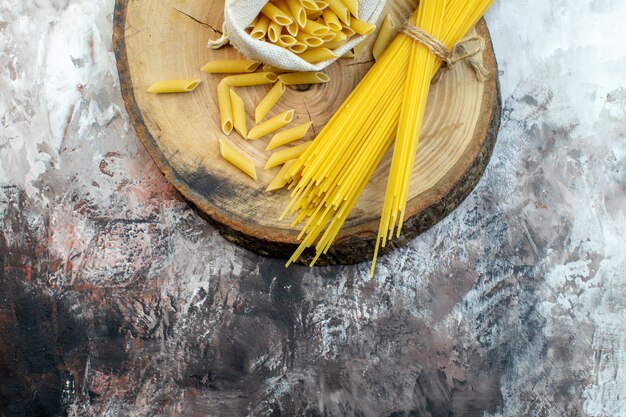 Top view raw yellow pasta on light surface