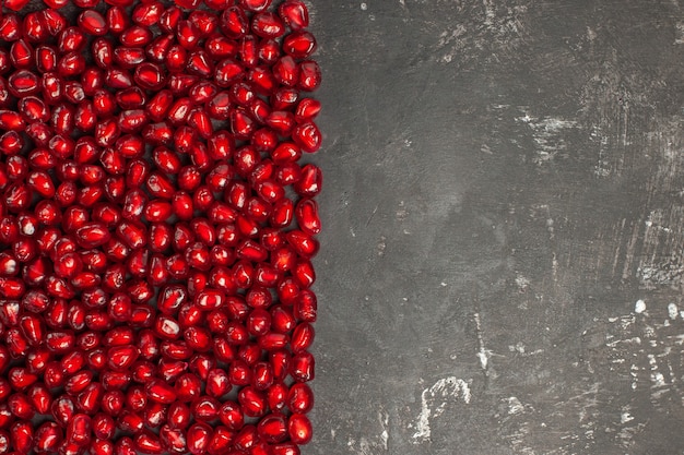 Top view of rectangular shape pomegranate seeds on dark surface