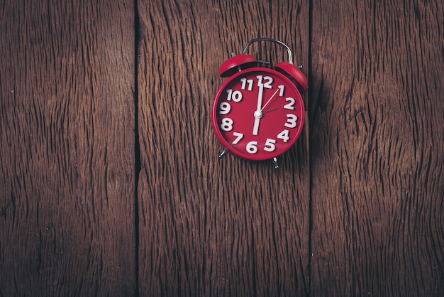 Top view red alarm clock on wood background